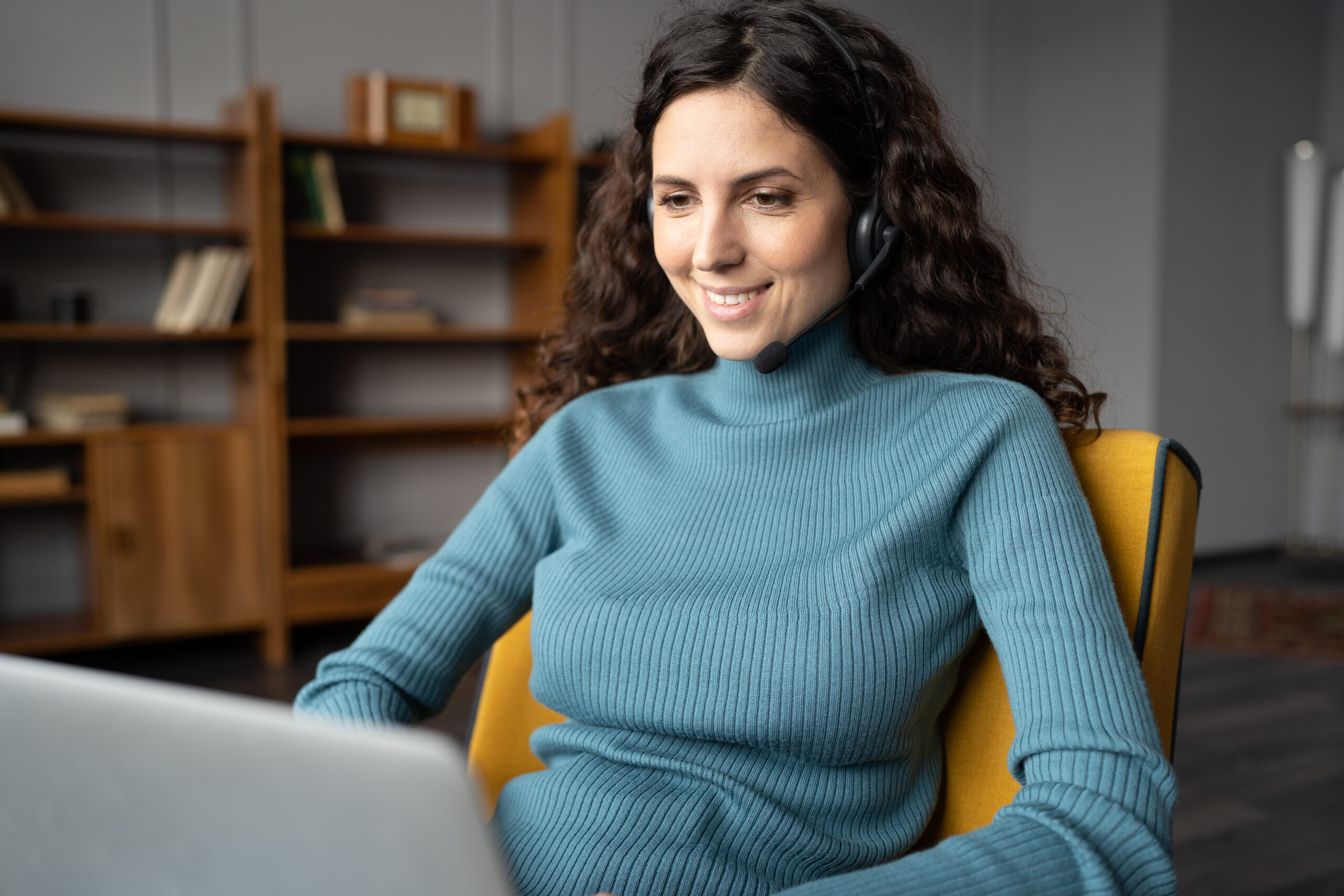 A smiling woman teaching an online class and talking to students during remote language lessons